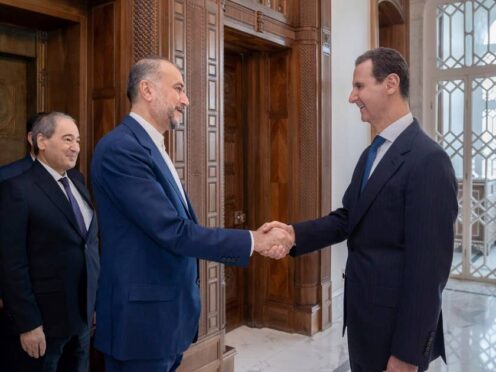 Syrian President Bashar Assad, right, welcomes Iranian Foreign Minister Hossein Amirabdollahian before their meeting in Damascus, Syria (Syrian Presidency Telegram page via AP)