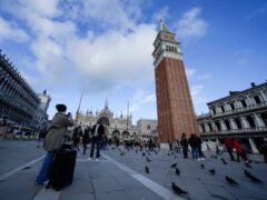 Tourists take pictures at the St Mark square in Venice (Luca Bruno/AP)