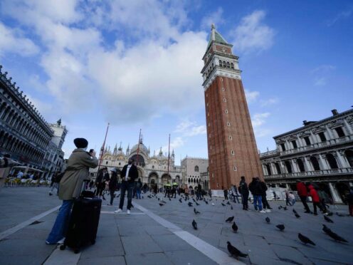 Tourists take pictures at the St Mark square in Venice (Luca Bruno/AP)