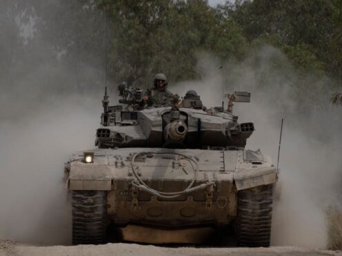 Israeli soldiers move on the top of a tank near the Israeli-Gaza border (AP)