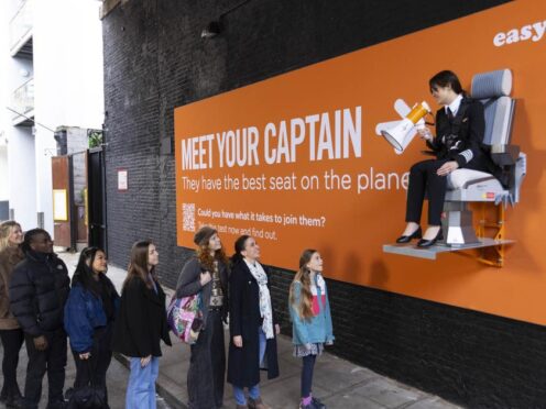 Pilot Sarah Ackerley sits on an interactive billboard in London at the launch of an easyJet campaign (David Parry/PA)