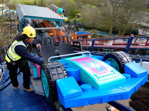Legoland team member Shenica Gumbs inspects a car on the Minifigure Speedway, as final checks are made to the new ride at Legoland Windsor Resort, in Berkshire (Andrew Matthews/PA)