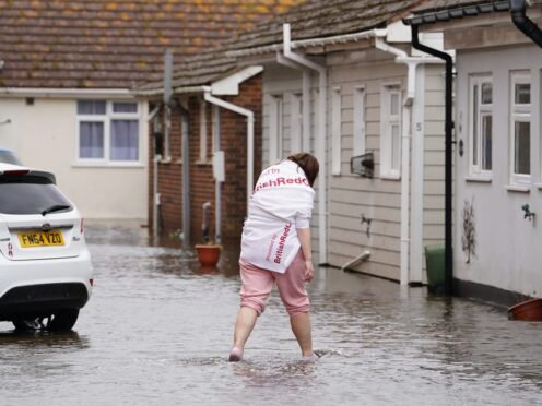 A resident wades through flood water in Littlehampton (Gareth Fuller/PA)