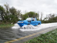 A car drives through flood water in Littlehampton, West Sussex (Gareth Fuller/PA)