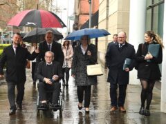 Kingsmill massacre survivor Alan Black, front, and Karen Armstrong, centre, the sister of victim John McConville, with friends and supporters of the victims arriving at Laganside Courts, Belfast (Oliver McVeigh/PA)