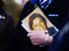 An attendee holds photograph of Pc Yvonne Fletcher during a 40th anniversary memorial service in St James’s Square, London (Victoria Jones/PA)