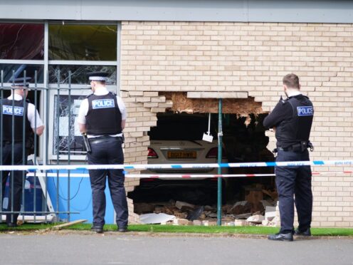 Police officers stand beside the debris and damage to the Beacon Church of England Primary School (Peter Byrne/PA)