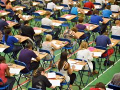 A-level students sit an A-level maths exam inside a sports hall