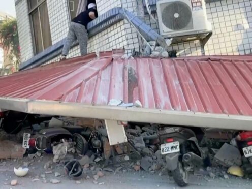 A man checks a partially collapsed building in Hualien, eastern Taiwan (TVBS via AP)