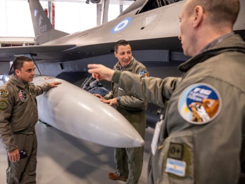 Argentine’s delegation members look at one of the F-16 planes Argentina is buying from Denmark in a hangar at Skrydstrup Airport in Jutland, Denmark (Bo Amstrup/Ritzau Scanpix via AP)