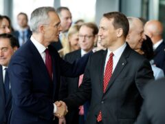 Nato Secretary General Jens Stoltenberg shakes hands with Poland’s Foreign Minister Radoslaw Sikorski (Geert Vanden Wijngaert/AP)