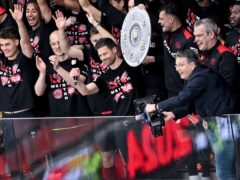 Coach Xabi Alonso, centre, and Bayer Leverkusen raise the Bundesliga trophy (David Inderlied/dpa via AP)