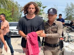 A Thai police officer escorts Daniel Sancho Bronchalo to Koh Samui Island court, southern Thailand, for an earlier hearing (Somkeat Ruksaman/AP)