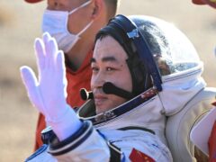 Chinese astronaut Tang Shengjie waves after returning to Earth (Bei He/Xinhua via AP)