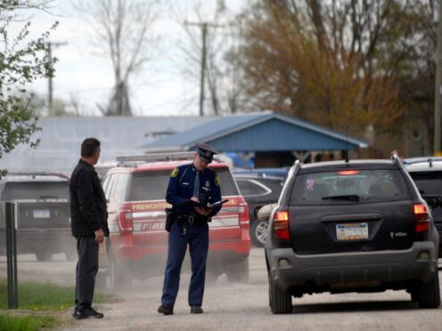 A law enforcement official monitors the perimeter of the Swan Creek Boat Club after a driver crashed a vehicle through a building where a children’s birthday party was taking place (Kathleen Kildee/Detroit News via AP)