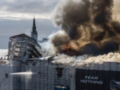 Firefighters work as smoke rises out of the Old Stock Exchange in Copenhagen, Denmark (Emil Nicolai Helms/Ritzau Scanpix via AP)
