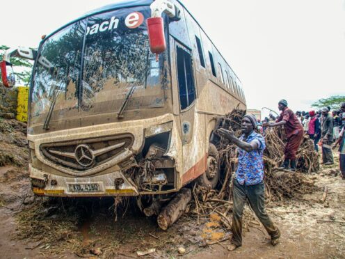 People try to move a bus that was washed away in Kenya (Patrick Ngugi/AP)