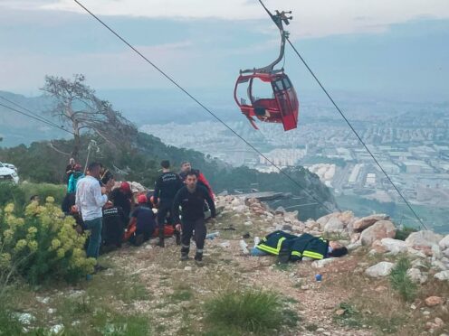 Rescue and emergency team members work with passengers of a cable car transportation system outside Antalya (Dia Images via AP)