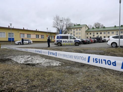 Police officers stand guard outside the school in Finland (Markku Ulander/Lehtikuva via AP)