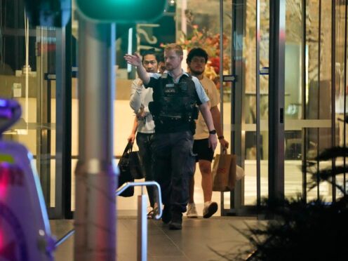 People are led out of Westfield Bondi Junction shopping centre, where multiple people were stabbed (Rick Rycroft/AP)