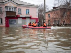 Emergency workers and police during evacuations in a flooded street after parts of a dam burst, in Orsk, Russia (AP)