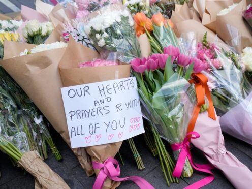 A note is left with flower tributes near the scene at Bondi Junction in Sydney (Rick Rycroft/AP)