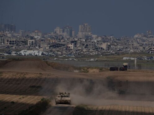 Israeli soldiers move on the top of a tank near the Israeli-Gaza border, as seen from southern Israel (Leo Correa/AP)