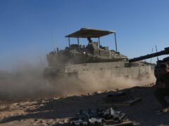 Israeli soldiers drive a tank in a staging area near the Gaza border (Tsafrir Abayov/AP)