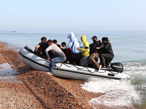 A group of people thought to be migrants arrive in an inflatable boat (Gareth Fuller/PA)