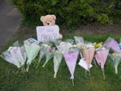Floral tributes laid on the corner of Laing Close and New North Road in Hainault, north-east London, where a 14-year-old boy, named locally as Daniel Anjorin, was killed (Yui Mok/PA)