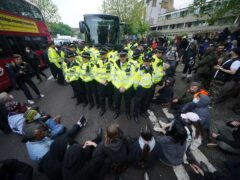 Police with protesters who formed a blockade around a coach which is parked near the Best Western hotel in Peckham, south London, to prevent the removal of migrants from the temporary accommodation (Yui Mok/PA)