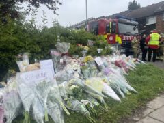 Flowers are left near the scene in Laing Close (Samuel Montgomery/PA)