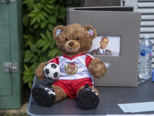 A teddy bear in an Arsenal top on a table at vigil at Hainault Underground Station Car Park, north east London, in memory of 14-year-old Daniel Anjorin, who was killed in a sword attack (Jeff Moore/PA)