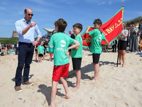 William speaks with members of Holywell Bay Surf Life Saving Club during a visit to Fistral beach in Newquay (Toby Melville/PA)
