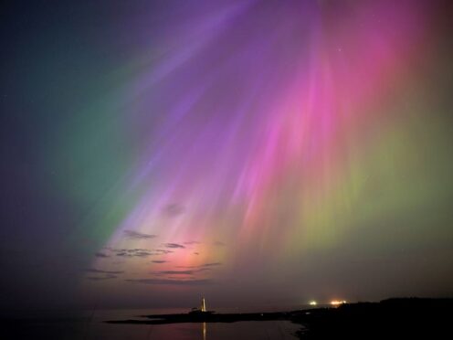 The aurora borealis, also known as the northern lights, glow on the horizon at St Mary’s Lighthouse in Whitley Bay on the North East coast (Owen Humphreys/PA)