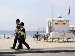Police officers at the scene of the fatal stabbing at Durley Chine Beach in Bournemouth (Angus Williams/PA)