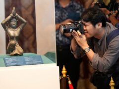 A photographer takes a picture of the ancient bronze kneeling woman sculpture during a repatriation ceremony at National Museum in Bangkok, Thailand (Sakchai Lalit/AP)
