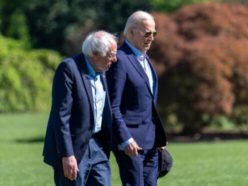 President Joe Biden, right, and Senator Bernie Sanders walk from Marine One upon arrival on the South Lawn of the White House in April (Alex Brandon/AP)