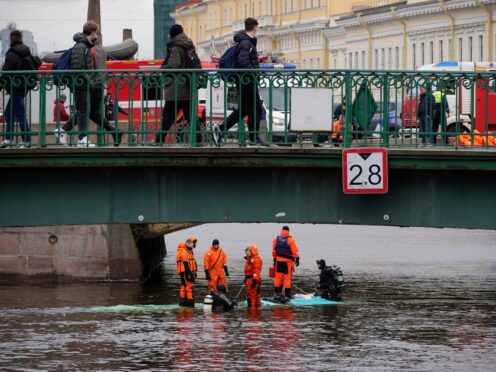 Emergency responders work to recover victims of the bus crash in St Petersburg (Dmitri Lovetsky/PA)