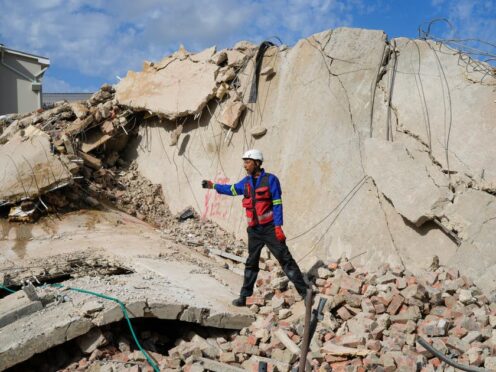 Rescue workers search the site of a building collapse in George, South Africa (Jerome Delay/AP)