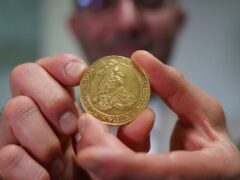Vicken Yegparian, vice president of numismatics, Stack’s Bowers Galleries, holds a golden coin once belonging to the collection of Danish king, Frederik VII, now part of LE Bruun’s collection, in Zealand, Denmark (James Brooks/AP)