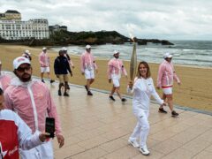 Zoe Grospiron carries the Olympic torch in Biarritz, southwestern France, on Monday (Nicolas Mollo/AP)