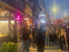 Crowds gathered outside a restaurant in Hackney after a shooting which injured three adults and a child (Ayo Adesina)