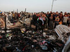 Palestinians look at the destruction after an Israeli strike (Jehad Alshrafi/AP)