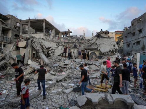 Palestinians look at the destruction after an Israeli airstrike in Deir al Balah, Gaza Strip, on Tuesday (Abdel Kareem Hana/AP)