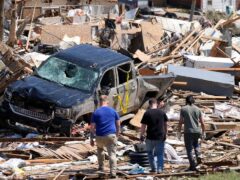 Residents assess the damage left behind by the tornado (Charlie Neibergall/AP)