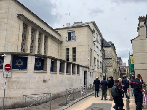 Firefighters stand in front the synagogue in Rouen after a man was shot and killed by police (Jeffrey Schaeffer/AP)