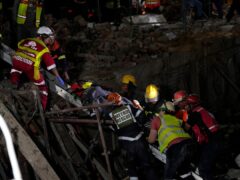 A survivor is bought to the surface at the scene of a building collapse in the city of George, South Africa (Nardus Engelbrecht/AP)