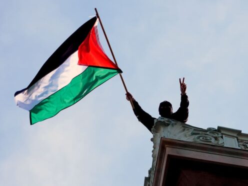 A student protester waves a Palestinian flag above Hamilton Hall on the campus of Columbia University (Mary Altaffer/AP)