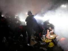 Police enter an encampment (AP)
